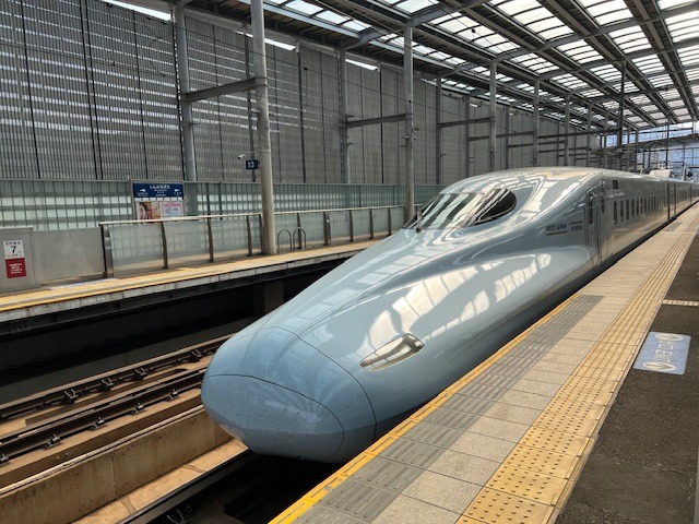 Světle modrý šinkansen Sakura na nádraží